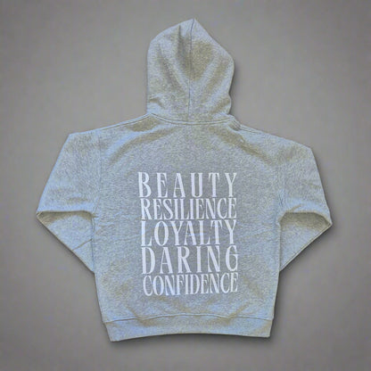 Gray hoodie with motivational text on the back against a beige background